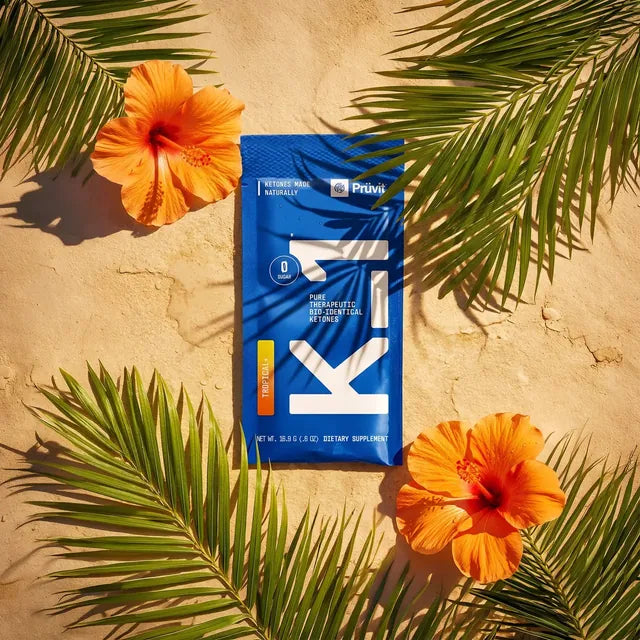 Bustina K1 Tropical su sabbia tra foglie di palma e fiori di ibisco
